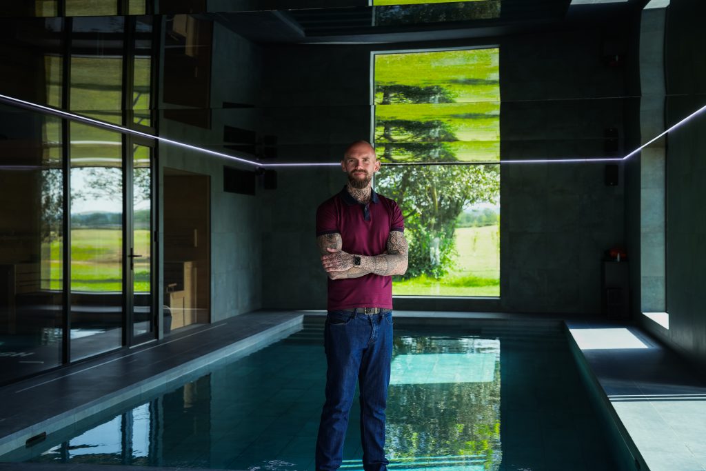 Man standing in modern indoor pool.